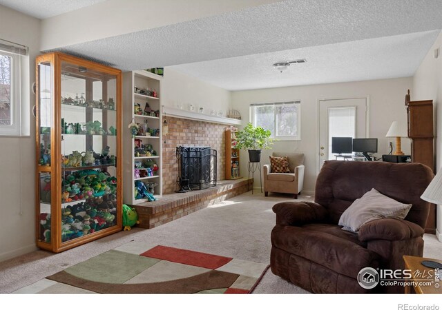 living room with carpet flooring, a fireplace, a textured ceiling, and baseboards