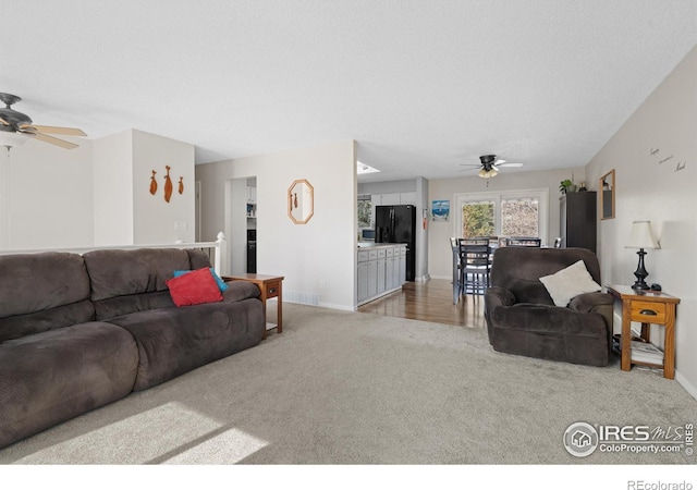 carpeted living room featuring a textured ceiling, baseboards, and ceiling fan