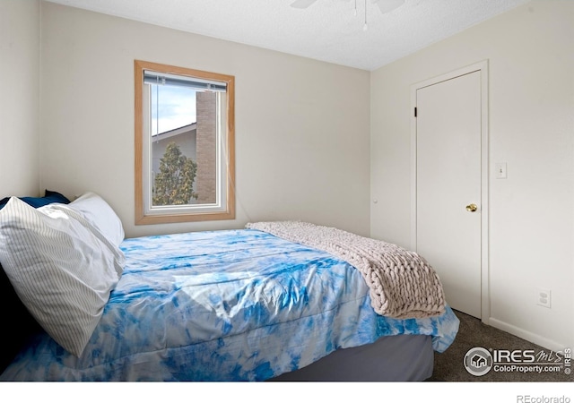 carpeted bedroom featuring a textured ceiling and a ceiling fan