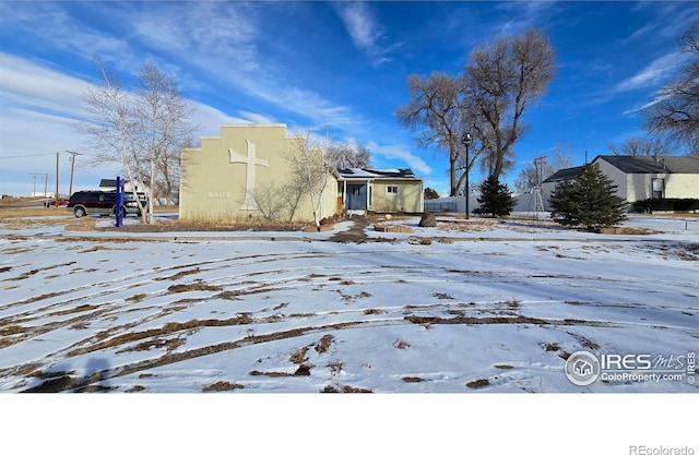 view of snowy exterior featuring stucco siding