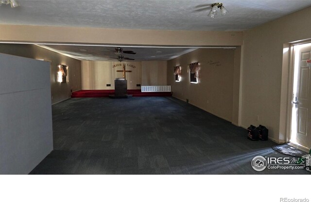 interior space featuring a textured ceiling and carpet floors