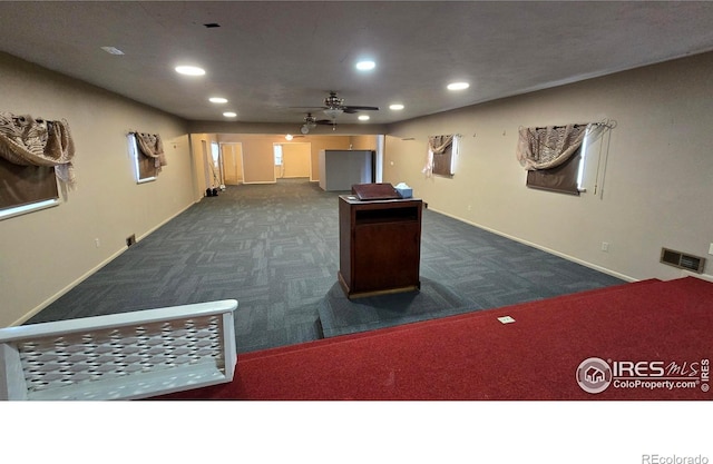 recreation room with recessed lighting, visible vents, dark carpet, and baseboards