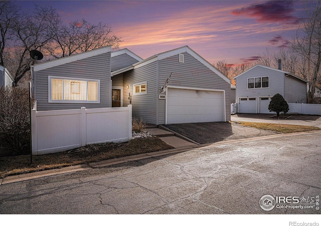 view of front facade featuring an attached garage and fence