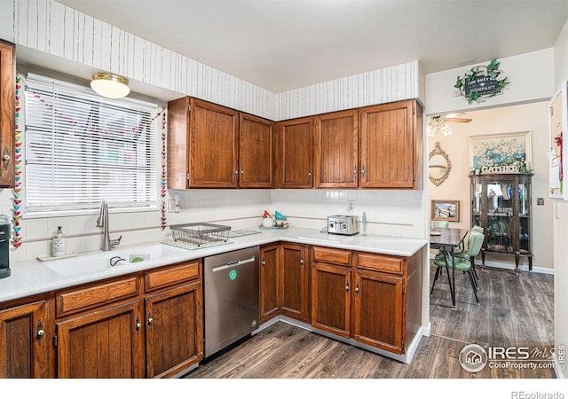 kitchen featuring dishwasher, dark wood-type flooring, a sink, and wallpapered walls