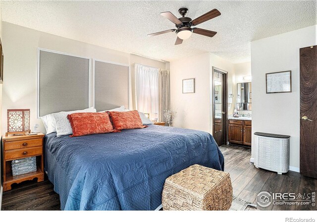 bedroom featuring dark wood-style floors, connected bathroom, a textured ceiling, and ceiling fan