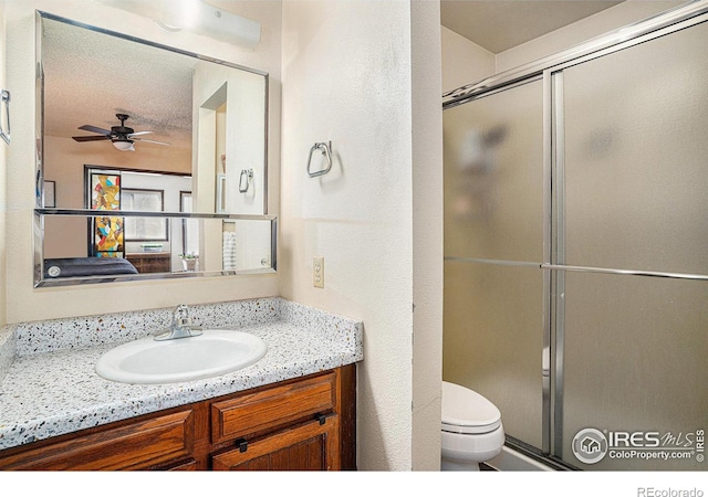 bathroom featuring a stall shower, toilet, vanity, and a ceiling fan