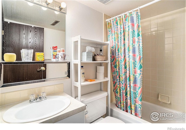 bathroom featuring visible vents, shower / tub combo with curtain, vanity, and toilet