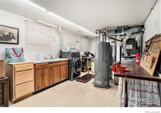 washroom with gas water heater, washer / clothes dryer, and cabinet space