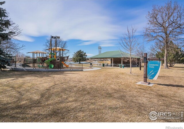 communal playground with a gazebo, a lawn, and fence