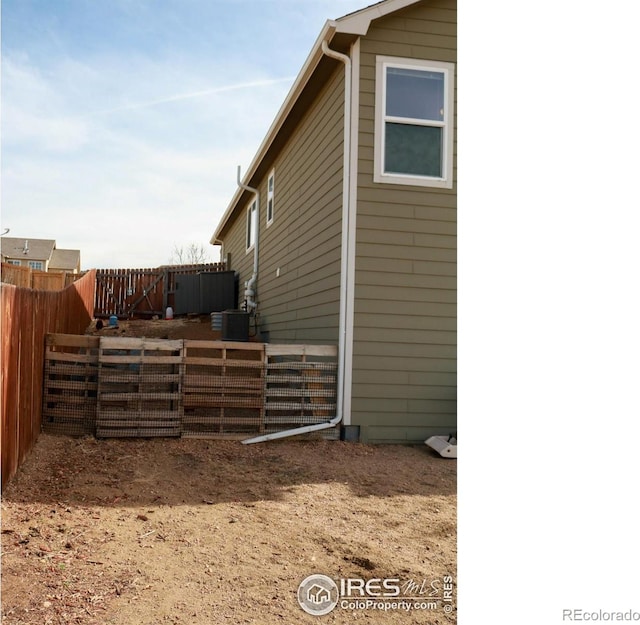 view of home's exterior with cooling unit and fence