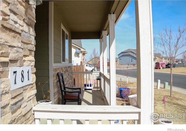 wooden terrace with a porch and a residential view