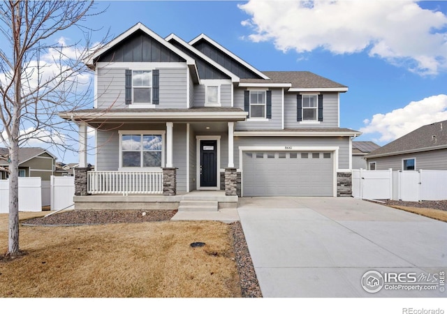 craftsman inspired home featuring a porch, fence, board and batten siding, concrete driveway, and a garage