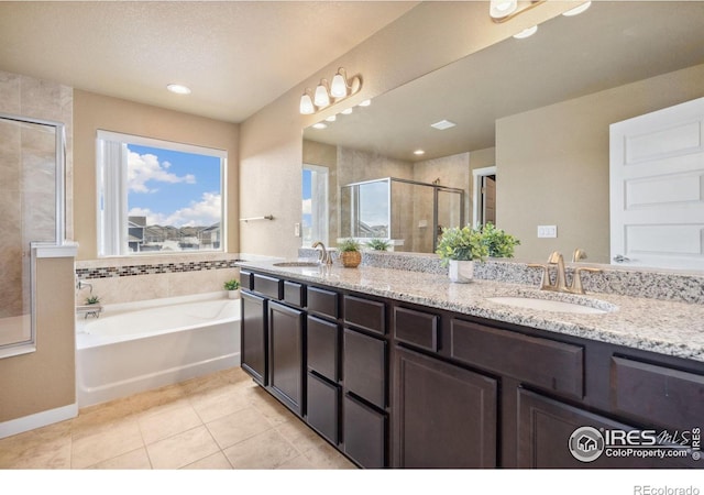 full bathroom with tile patterned flooring, a garden tub, a stall shower, and a sink