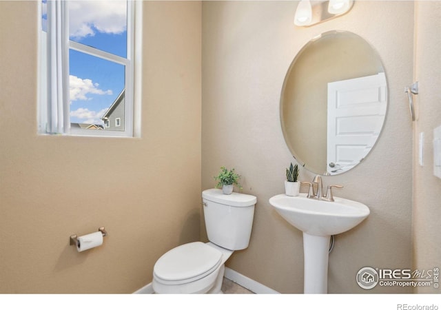 bathroom with baseboards and toilet