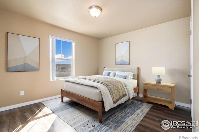 bedroom with baseboards and wood finished floors