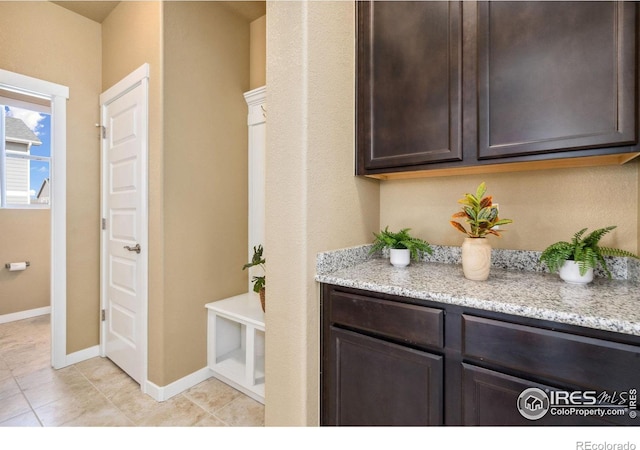 interior space with light tile patterned floors and baseboards