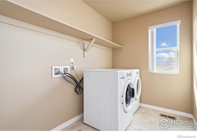 laundry room with washer and dryer, baseboards, light tile patterned flooring, and laundry area