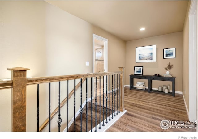 hall with recessed lighting, baseboards, an upstairs landing, and wood finished floors