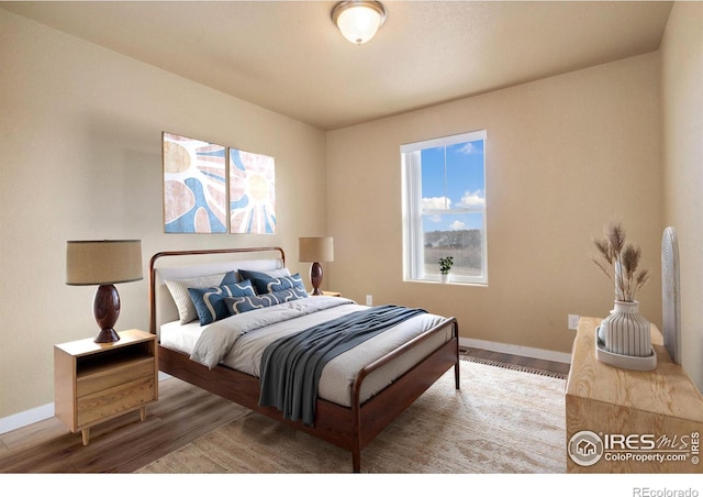 bedroom with baseboards and wood finished floors