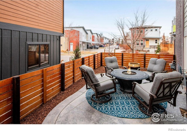 view of patio / terrace featuring a residential view, an outdoor fire pit, and fence