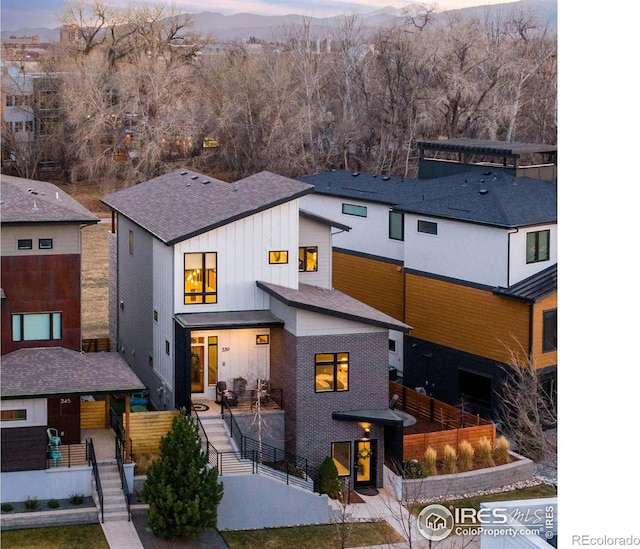 view of front of property with brick siding, a mountain view, board and batten siding, and stairs