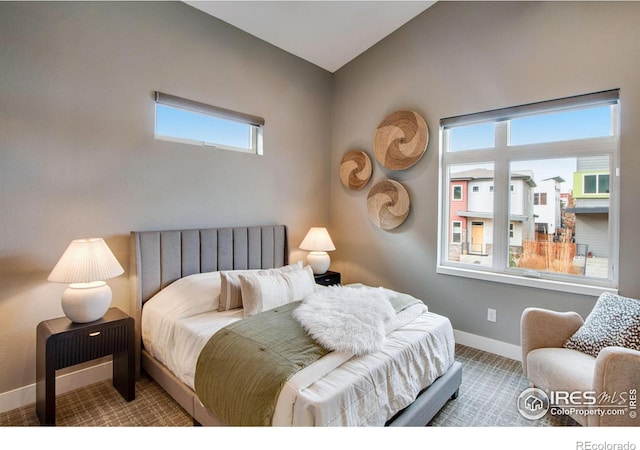 bedroom with baseboards, lofted ceiling, and carpet