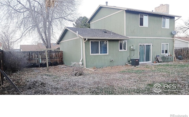 rear view of house with fence and a chimney