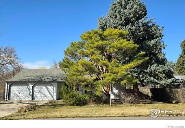 view of front facade featuring a garage, driveway, and a front yard