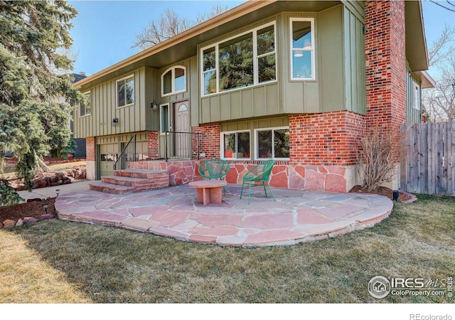 back of property featuring brick siding, board and batten siding, and fence