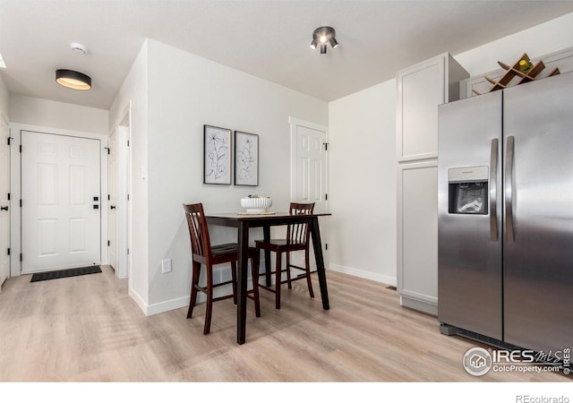 dining area featuring baseboards and light wood-style flooring