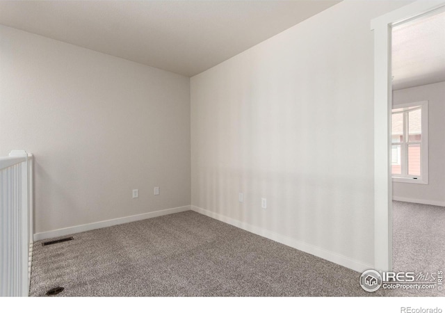 spare room featuring visible vents, baseboards, and carpet floors