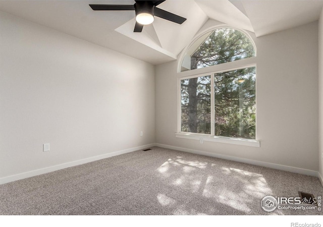 empty room with a wealth of natural light, baseboards, carpet, and vaulted ceiling