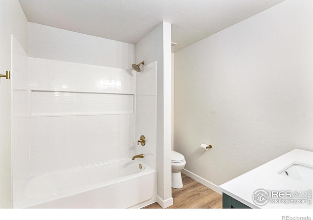 bathroom featuring vanity, toilet, wood finished floors, and shower / bathtub combination