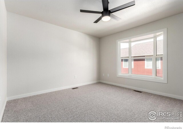 spare room featuring visible vents, carpet floors, and baseboards