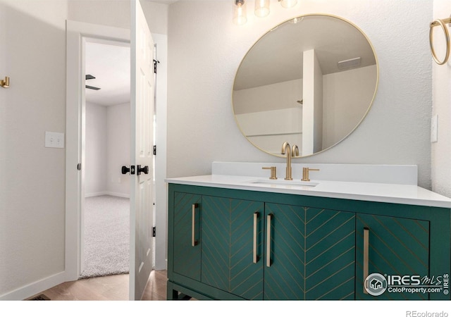 bathroom featuring baseboards, wood finished floors, and vanity