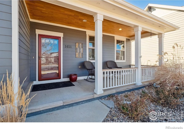 view of exterior entry featuring covered porch