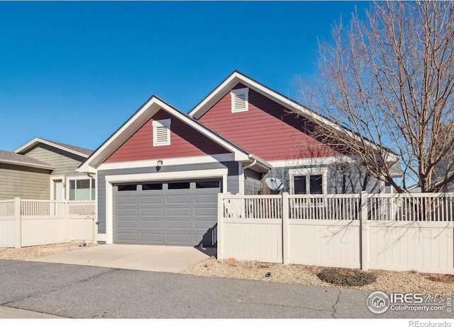 view of front of house featuring driveway, a garage, and fence