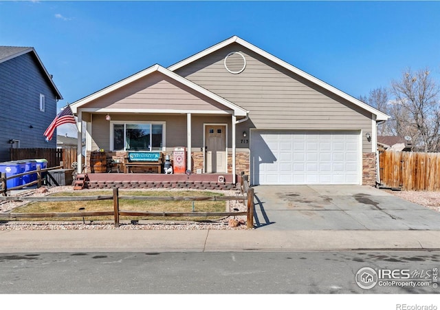 view of front of property with a fenced front yard, driveway, a porch, and an attached garage