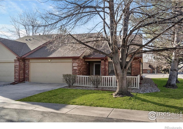 view of front facade with brick siding, a front lawn, covered porch, driveway, and an attached garage