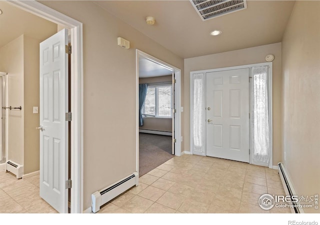 entryway featuring baseboard heating, visible vents, and a baseboard radiator