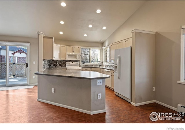 kitchen with tasteful backsplash, white appliances, a peninsula, and wood finished floors