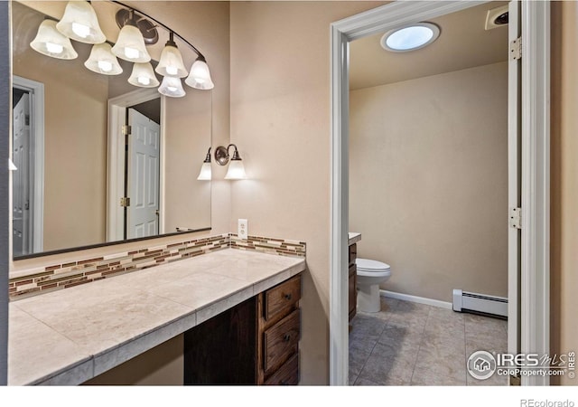 bathroom featuring decorative backsplash, toilet, vanity, and a baseboard radiator