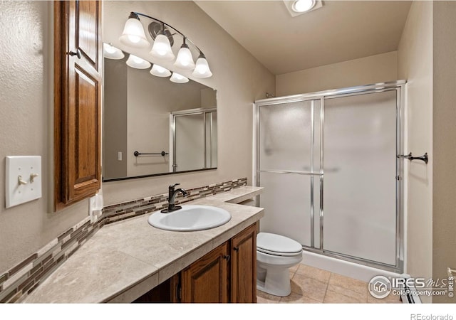 full bathroom featuring tile patterned flooring, a shower stall, toilet, decorative backsplash, and vanity