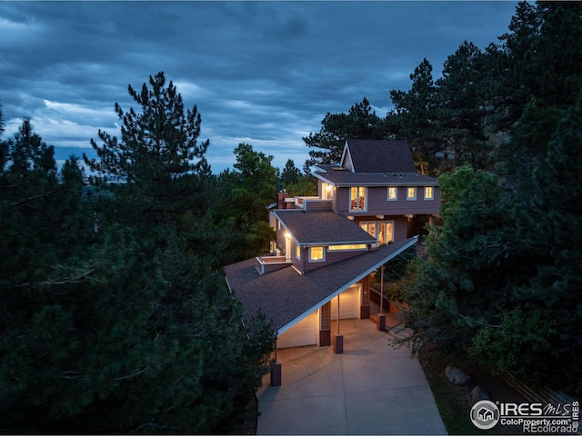 view of front of house with a garage, a balcony, a shingled roof, and concrete driveway
