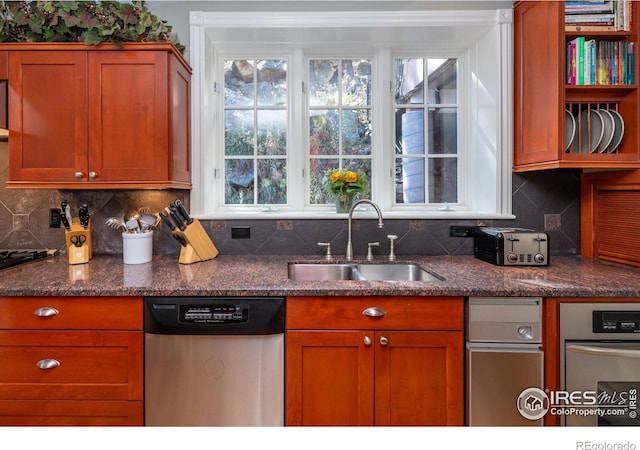 kitchen with a sink, decorative backsplash, stainless steel dishwasher, and brown cabinets