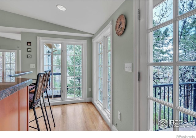 entryway with vaulted ceiling, plenty of natural light, and light wood finished floors