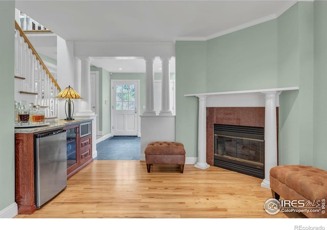 interior space with wood finished floors, refrigerator, baseboards, open floor plan, and a tile fireplace