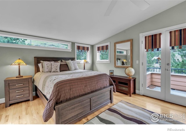 bedroom with light wood-style floors, vaulted ceiling, french doors, and access to exterior