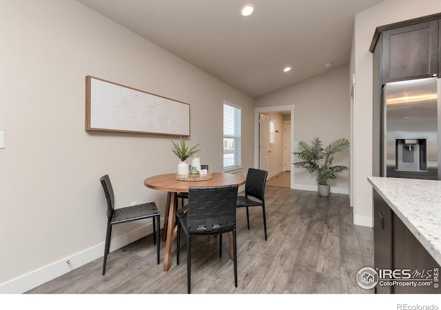 dining room with lofted ceiling, light wood-style flooring, recessed lighting, and baseboards