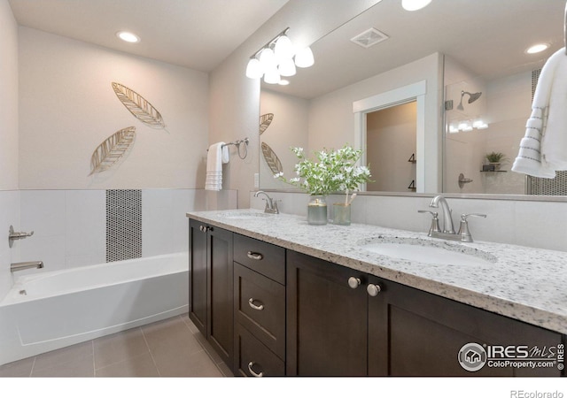 bathroom featuring a sink, visible vents, double vanity, and tile patterned floors